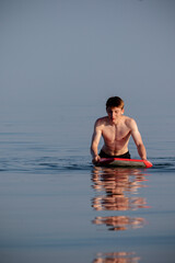 Teenage boy swimming with a body board