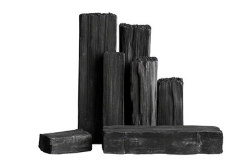 Charcoal briquettes stacked, varying lengths, against a stark black background