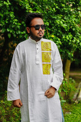 A boy wearing dark glasses and a Punjabi is greeting the puja