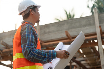 inspector or engineer is inspecting construction and quality assurance new house using a blue print. Engineer or architects or contactor work to build the house before handing it over to the homeowner