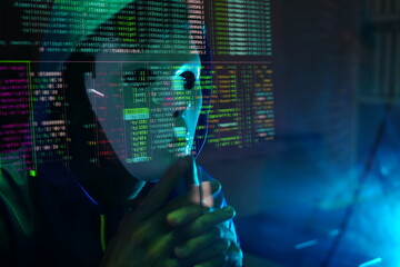 male hacker wearing a white mask sits in front of a screen, hands typing amid glowing cyber attack alerts and red binary code, symbolizing hacking, data breach, and malware in the night