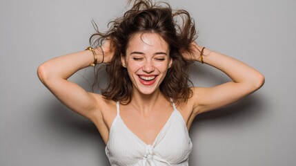 Fototapeta premium portrait of a happy young woman dancing on gray background no logos no brands ar 169