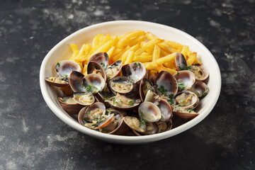 Steamed Clams with herbs and French fries in a white plate