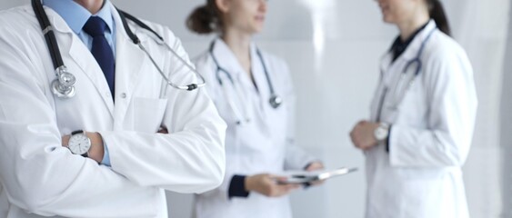 Medical team of doctors collaborating and consulting in a bright hospital setting, showcasing patient care, professionalism, and teamwork among healthcare workers