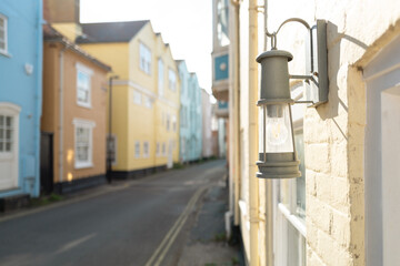 Shallow focus of a front door lantern seen within a narrow street in a picturesque seaside town in the East of England. Note the double yellow lines, meaning no parking.