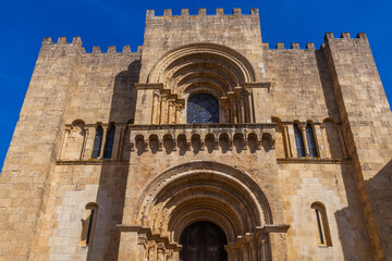 Fototapeta premium A low-angle shot captures the imposing, sunlit facade of a historic stone cathedral