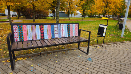 Colorful bench with decorative patterns in autumn park setting  