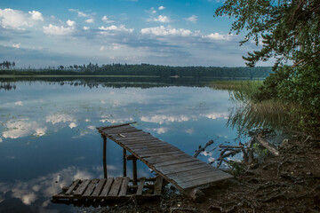 A tranquil lakeside dock surrounded by the scenic beauty of natures reflection and calmness