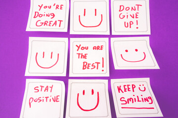 Sticky notes with a positive message, on a purple background.
