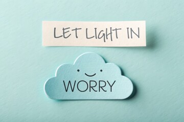 Cute cloud shape with Worry and Let Light In on light blue background