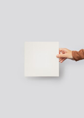 Obraz premium Hand Holding Blank Square Card Mockup on Grey Background