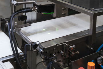 Conveyor belt for packaging with laser motion sensors.