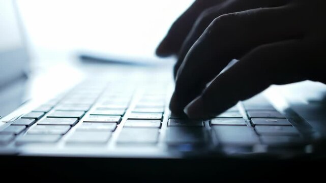 Close-up of a person typing on a laptop keyboard, focused on technology and communication.