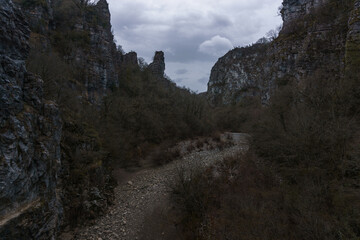 View of the impressive Vikos gorge in the Zagoria region at Pindus Mountains on a dark winter day with atmospheric mood, Epirus, Greece
