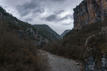 View of the impressive Vikos gorge in the Zagoria region at Pindus Mountains on a dark winter day with atmospheric mood, Epirus, Greece