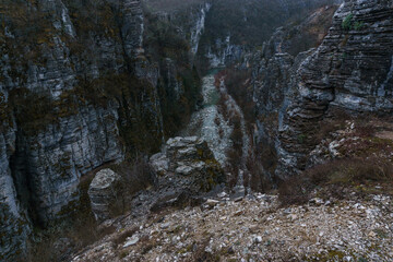 Rocky landscape of the Voidomatis Potamos valley in the Zagoria region at Pindus Mountains on a dark winter day with atmospheric mood, Epirus, Greece