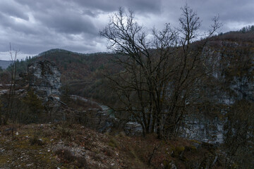 Rocky landscape of the Voidomatis Potamos valley in the Zagoria region at Pindus Mountains on a dark winter day with atmospheric mood, Epirus, Greece