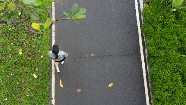 Woman walking on a path in a park, overhead view