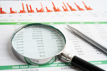 Magnifying glass on spreadsheet and graph paper. Financial data economy, Business.