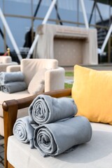 Cozy outdoor lounge with cushioned armchairs, rolled-up blankets, and a pop of yellow