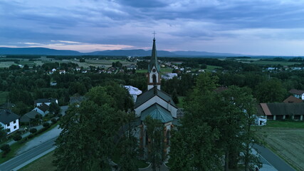 Aerial view of church in osiek with mountains in the background at dusk