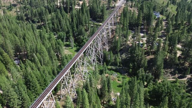 Clio trestle in northern California. Very high angle flyover shot of the structure that shows the trestle and surrounding forest.