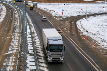 The multi-lane road is equipped with lighting and metal fences that serve as a protective barrier.