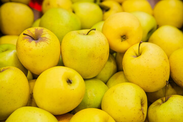 Apples are yellow in the window of a store or market.