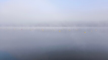 Early, quiet, and misty morning on Liebenberger See, Brandenburg, Germany. Scenic lake view with fog and calm water.