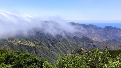 Mountain landscape of Anaga Rural Park, Tenerife. Rolling clouds descending over green valleys and...