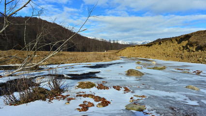 Obraz premium The Teleajen River frozen in the Cheia area, Prahova. Cold weather, Carpathian Mountains.