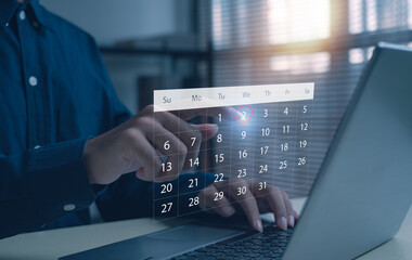 Businessman using laptop and touching virtual calendar date 2, concept of digital planning, schedule management, online productivity, time control, and modern technology workspace.