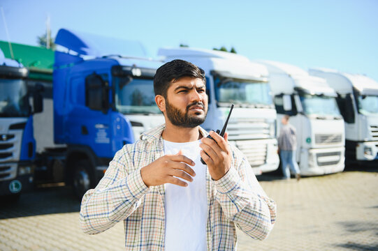 Logistics manager using walkie talkie at truck stop