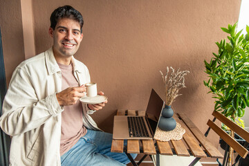 Young Hispanic man teleworking from home on balcony