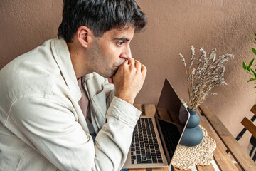 Young hispanic man concentrating while teleworking from home