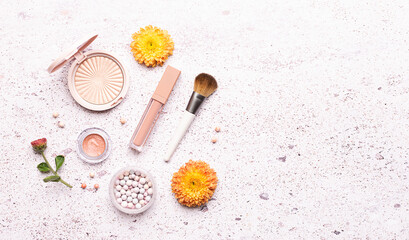 Decorative cosmetic products in autumn colors and beautiful flowers on light marble background top view. Cosmetic sale and promo banner.
