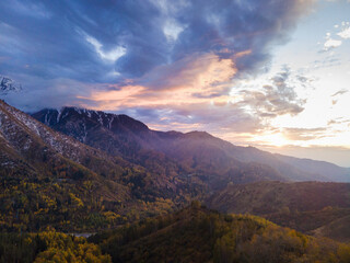 A stunning autumn landscape in the mountains near Almaty, Kazakhstan. Yellow foliage in the mountains against the backdrop of sunset, golden hour in autumn in the highlands.