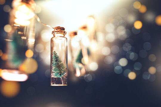 Mini Christmas tree in glass bottle with glowing bokeh lights, creative holiday decoration background for winter celebration, festive atmosphere with warm light and magic feeling, Christmas concept