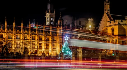 Fototapete Londoner Roter Bus Classic London red bus navigates through a brightly lit street with Christmas decorations and busy foot traffic. Ideal for travel, holiday, or urban lifestyle themes.  © alexey_fedoren