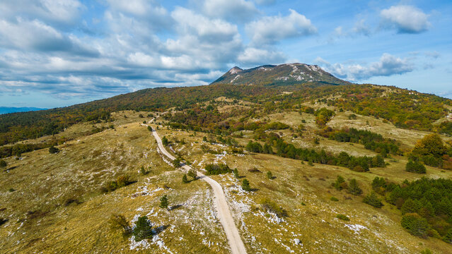 Aerial view of Mount Učka (Ucka) ridge with Vojak peak, winding mountain road, and autumn landscape near Brgud and Mala Učka, Istria, Croatia. Scenic panorama of Učka Nature Park