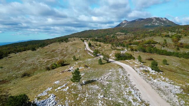 Aerial view of Mount Učka (Ucka) ridge with Vojak peak, winding mountain road, and autumn landscape near Brgud and Mala Učka, Istria, Croatia. Scenic panorama of Učka Nature Park