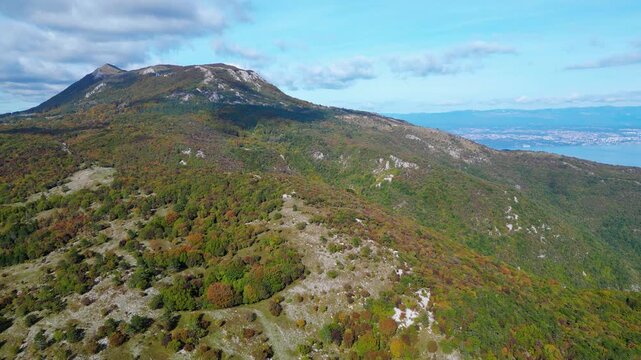 Aerial view of Mount Učka (Ucka) ridge with Vojak peak, winding mountain road, and autumn landscape near Brgud and Mala Učka, Istria, Croatia. Scenic panorama of Učka Nature Park