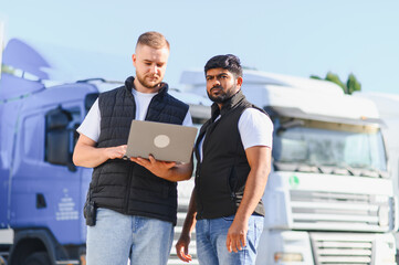 Truckers collaborating on logistics management using laptop