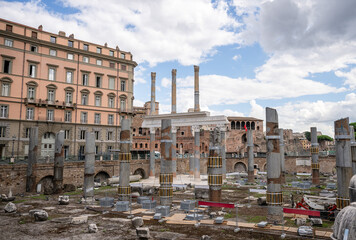Ancient Roman ruins with stone columns and historical buildings under cloudy sky