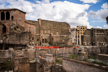Ancient stone ruins and old buildings in historic center of Rome under cloudy sky