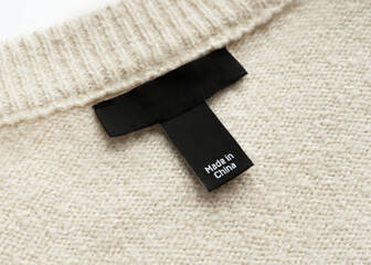 Black 'Made in China' Label on Beige Knitted Sweater