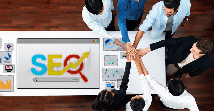 A diverse team engages in dynamic collaboration to develop SEO strategies, showcasing teamwork and innovative solutions in a modern office space with digital technology. Trope