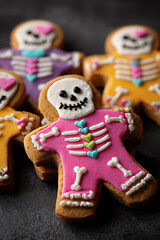 Close-up of gingerbread cookies decorated as skeletons on a black background. Festive and spooky treat for Day of the Dead or Halloween celebrations