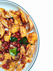 Traditional Indonesian Cuisine Spicy Dried Fish with Peanuts on a White Plate