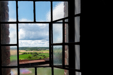 Fototapeta premium looking out into agricultural fields meadows and wind turbines through Gniew Castle window